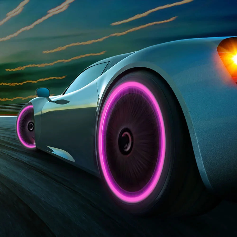A silver sports car drives on a road at sunset with glowing pink tire valve caps and taillight illumination.