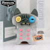 A gray plush toy resembling an ugly monster with large blue eyes and prominent teeth.