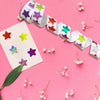A roll of 500 glitter star stickers in various colors is displayed on a pink background.
