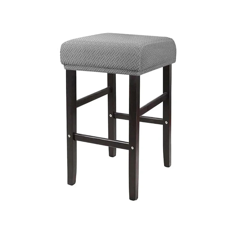 A gray bar stool slipcover made of stretchy jacquard fabric with an elastic edge.