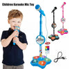 A child is holding a colorful karaoke microphone toy with a stand and built-in speaker.