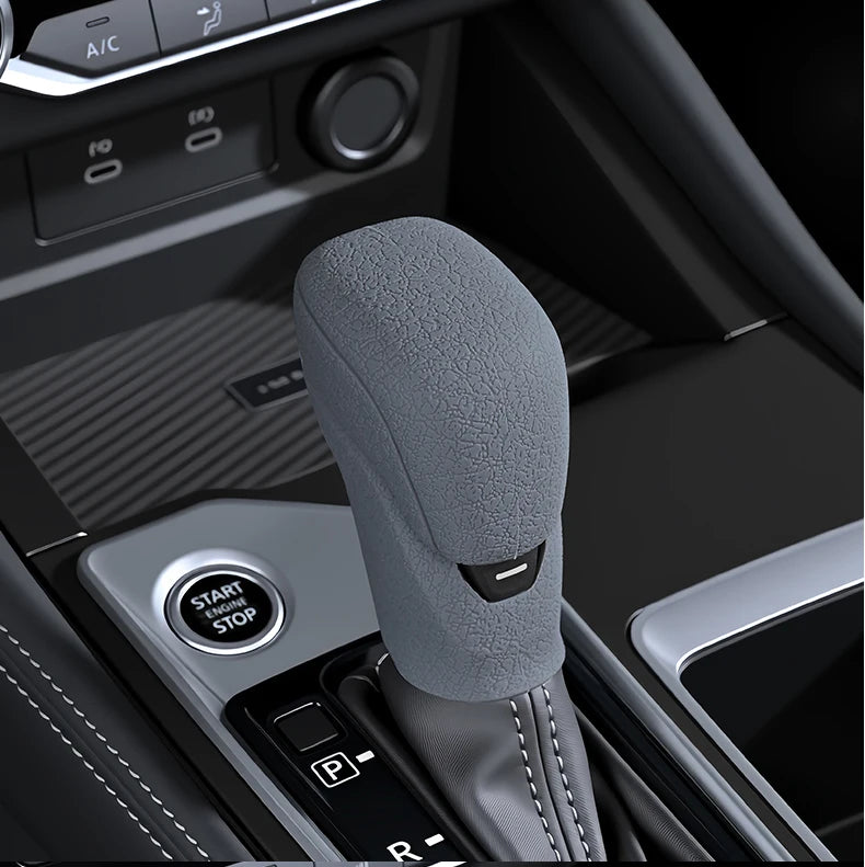 A close-up view of a gray silicone gear shift cover resting in the center console of a vehicle.