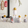 A set of handcrafted astronaut figurine resin spaceman desk decor in white and gold colors.