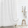 White boho waterproof shower curtain with a chevron pattern hanging on a white tiled wall