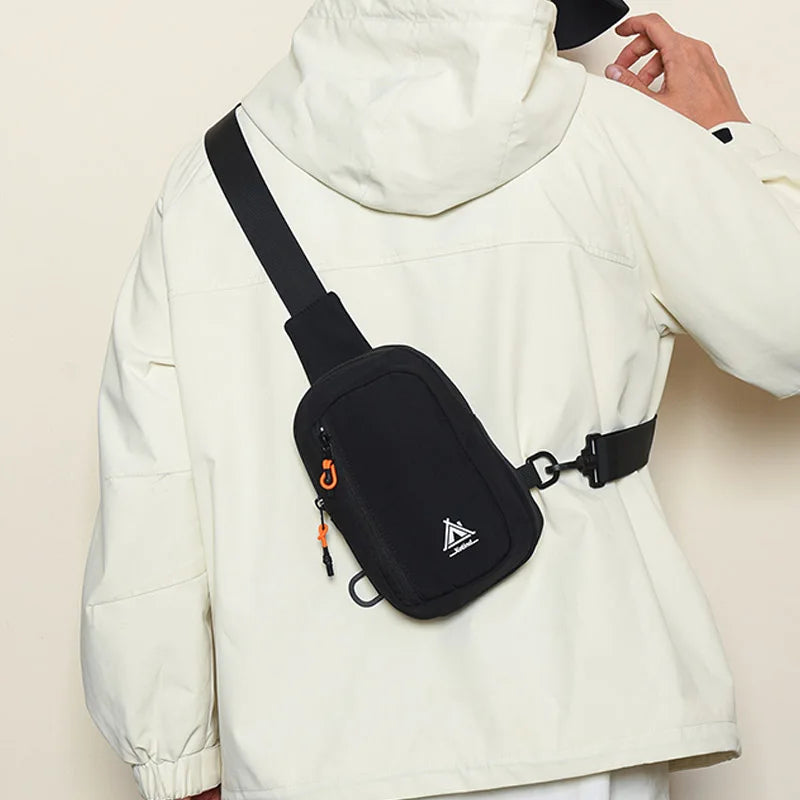 A white jacket features a black water-resistant nylon chest sling bag with an orange detail.