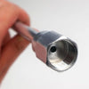 A hand is holding a metallic airless paint sprayer extension pole with a threaded tip.