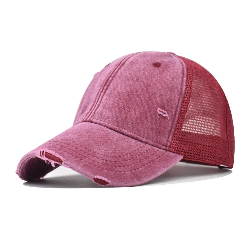 Nahaufnahme einer Vintage-Baseballkappe aus verwaschenem, staubrosa, mit Netzrücken.