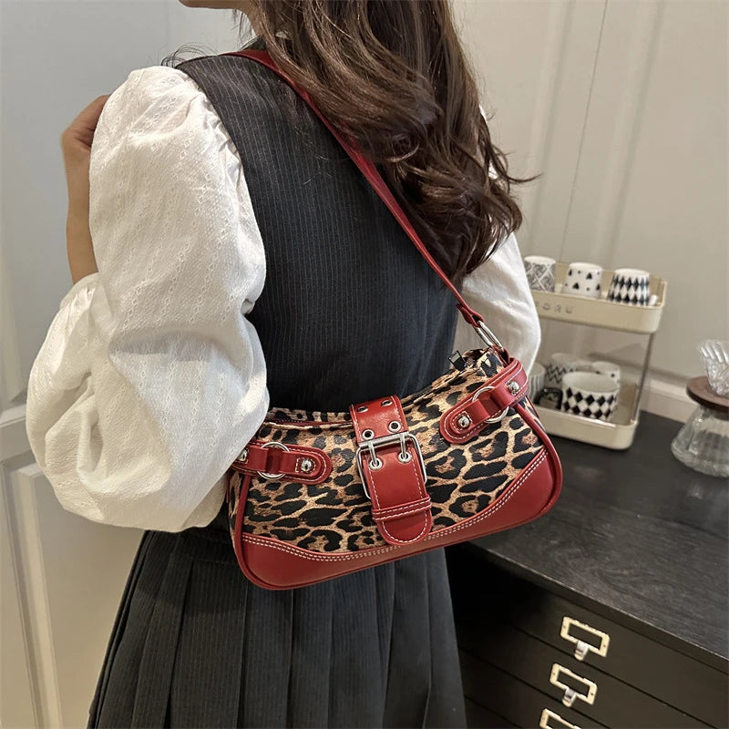 A woman holds a red leopard print PU leather shoulder bag against a dark gray dress.