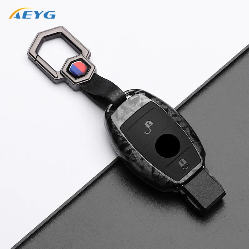 A slim carbon fiber car key cover with a metal clasp and electronic components.