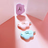 Three cloud-shaped retractable letter openers in purple, pink, and light blue displayed on a soft pink background.