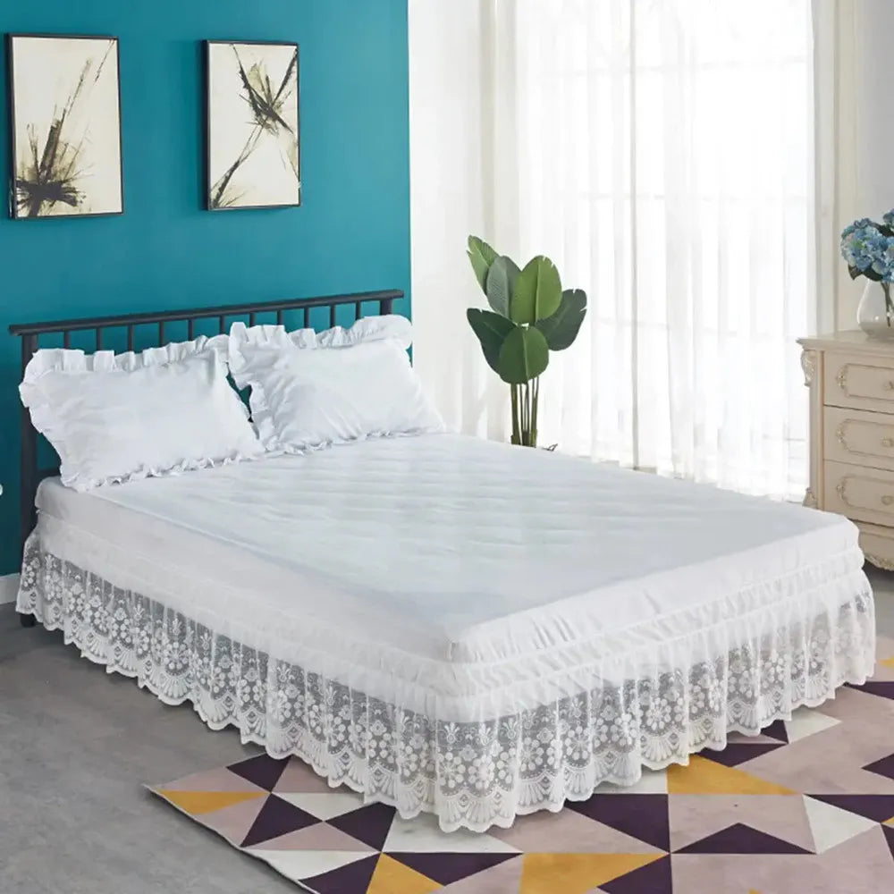 White ruffled lace bed skirt on a bed with a dark headboard and light blue wall.