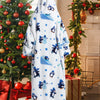 A white and blue patterned oversized wearable blanket hoodie with a hood displayed in a festive holiday setting.