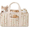 A beige floral diaper organizer bag with multiple compartments and a soft bear-themed insert.
