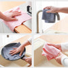 Hands are shown using a reusable microfiber cleaning towel to wipe down a sink or faucet.