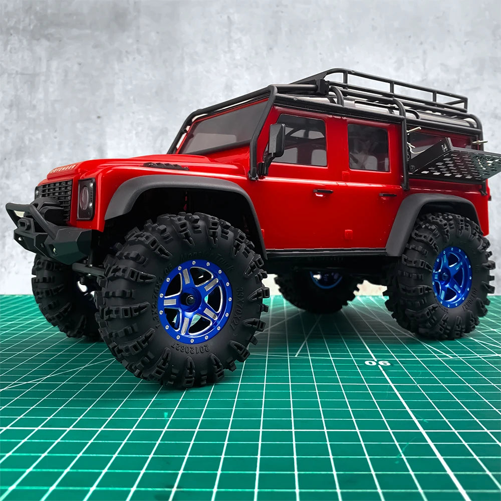 Red RC crawler vehicle with black roof rack and large mud terrain wheels on a green grid surface.