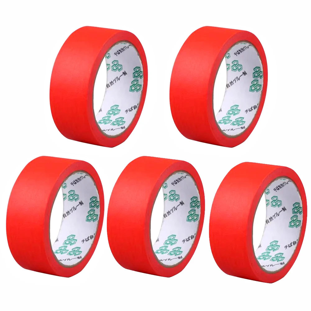 Tres rollos de cinta de enmascarar roja con marcas verdes mostrados de lado.