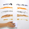 A hand holds a sheet of multi-purpose magic cleaning sponges showing various colors and textures.