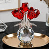 A crystal rose sculpture with a bouquet of red reflective roses displayed on a gold plate.