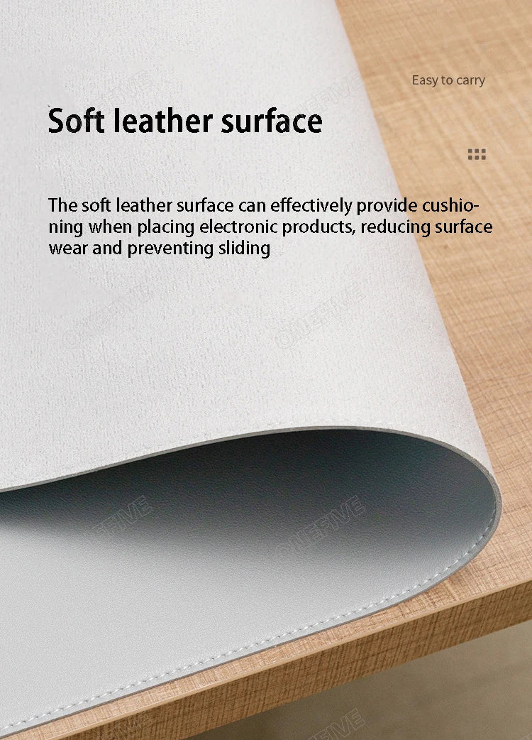 A close-up view of a soft leather surface desk mat in light gray, showing its texture and thickness.