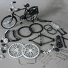 Eine Sammlung von Teilen und einem Fahrrad im Retro-Stil, einschließlich Rädern, Lenkern und Komponenten.