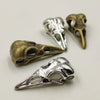 A set of five silver and bronze gothic skull and crow head charms for jewelry making