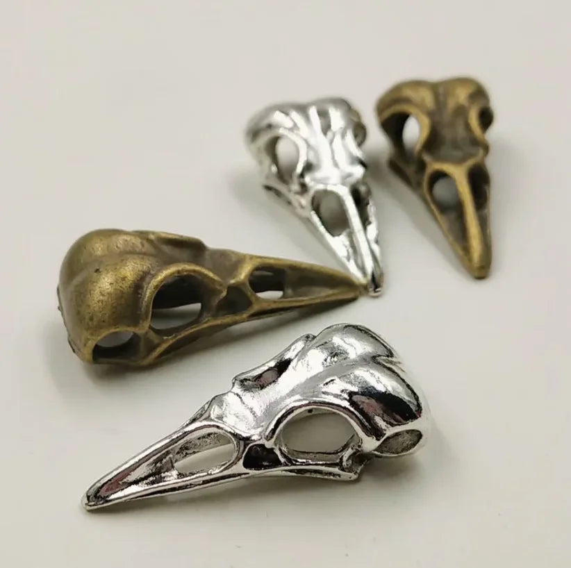 A set of five silver and bronze gothic skull and crow head charms for jewelry making