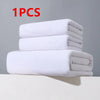 One stack of white microfiber bath towels resting on a white surface.