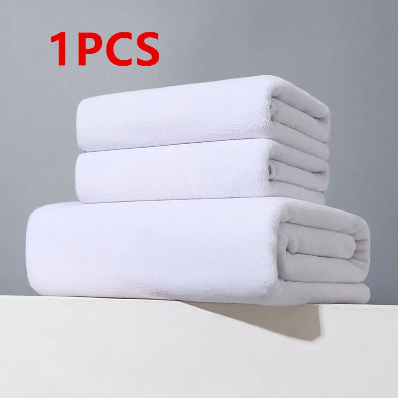 One stack of white microfiber bath towels resting on a white surface.