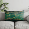 A decorative pillow featuring a teal background with abstract gold lines and speckles.