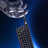 Nahaufnahme einer mechanischen Gaming-Tastatur mit hot-swappable Switches, gehalten von einer metallischen Roboterhand.