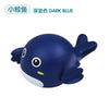 A dark blue wind-up bath toy shaped like a cartoon whale with large eyes and fins.