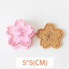 A set of two pink and tan floral cookie cutters featuring cherry blossom, peach blossom, and sunflower designs.