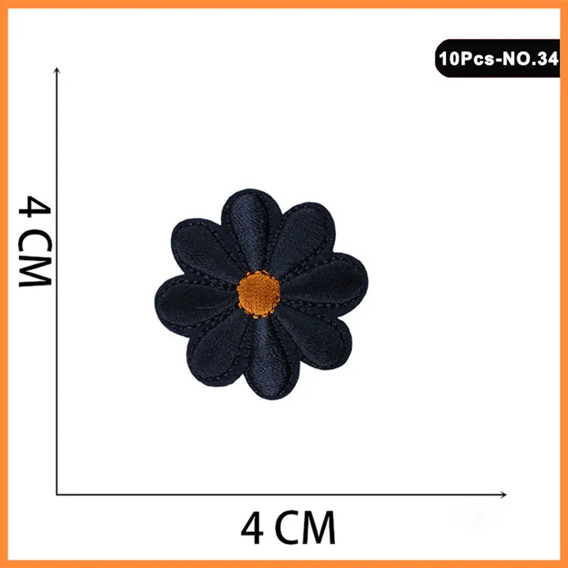 A black embroidered iron-on patch shaped like a flower with an orange center.