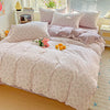 A pink floral duvet cover set with a matching flat sheet and pillows displayed on a bed.