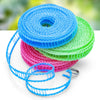Blue, pink, and green portable windproof clothesline string coiled on a white surface.