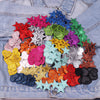 A collection of colorful glitter heart and star iron-on embroidered patches in various shades arranged on a denim fabric.