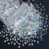 A close-up view of shiny holographic star sequins scattered across a dark background.