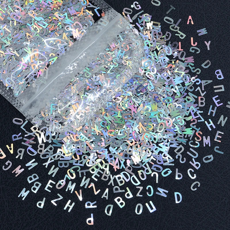 A close-up view of shiny holographic star sequins scattered across a dark background.