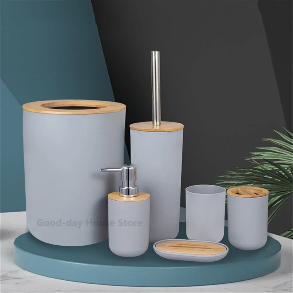 A set of bathroom organizers made of light gray ceramic and bamboo, including a soap dispenser and soap dish.