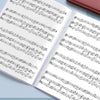 A close-up of an A4 expanding file organizer with clear pocket dividers showing sheet music pages.