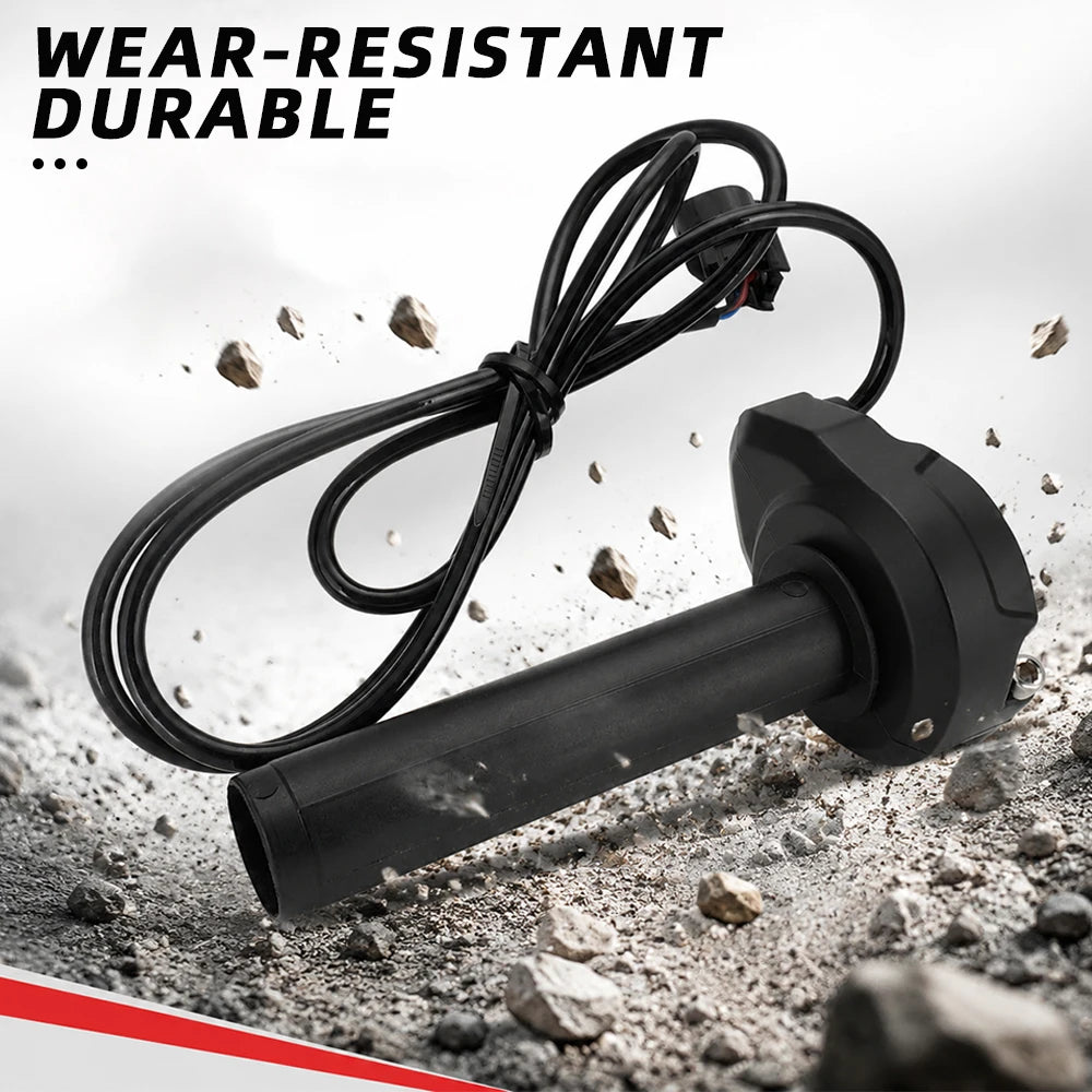 Black electric bike throttle grip with a coiled cable lying on a rough surface.