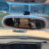 Rearview mirror covers with a plush bear and pig design installed in a car interior.