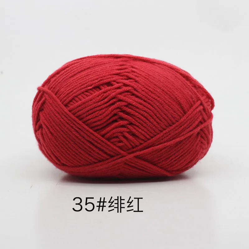 A ball of bright red 4-ply milk cotton yarn for knitting and crochet.