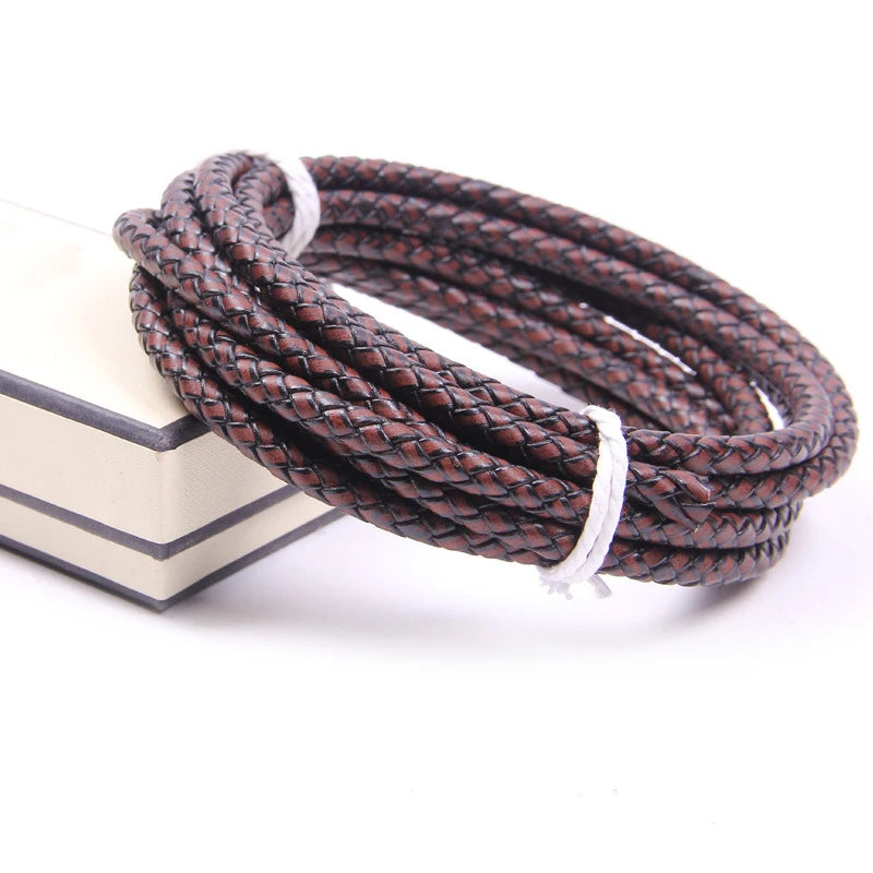A dark brown braided leather cord with white ends coiled on a light-colored surface.