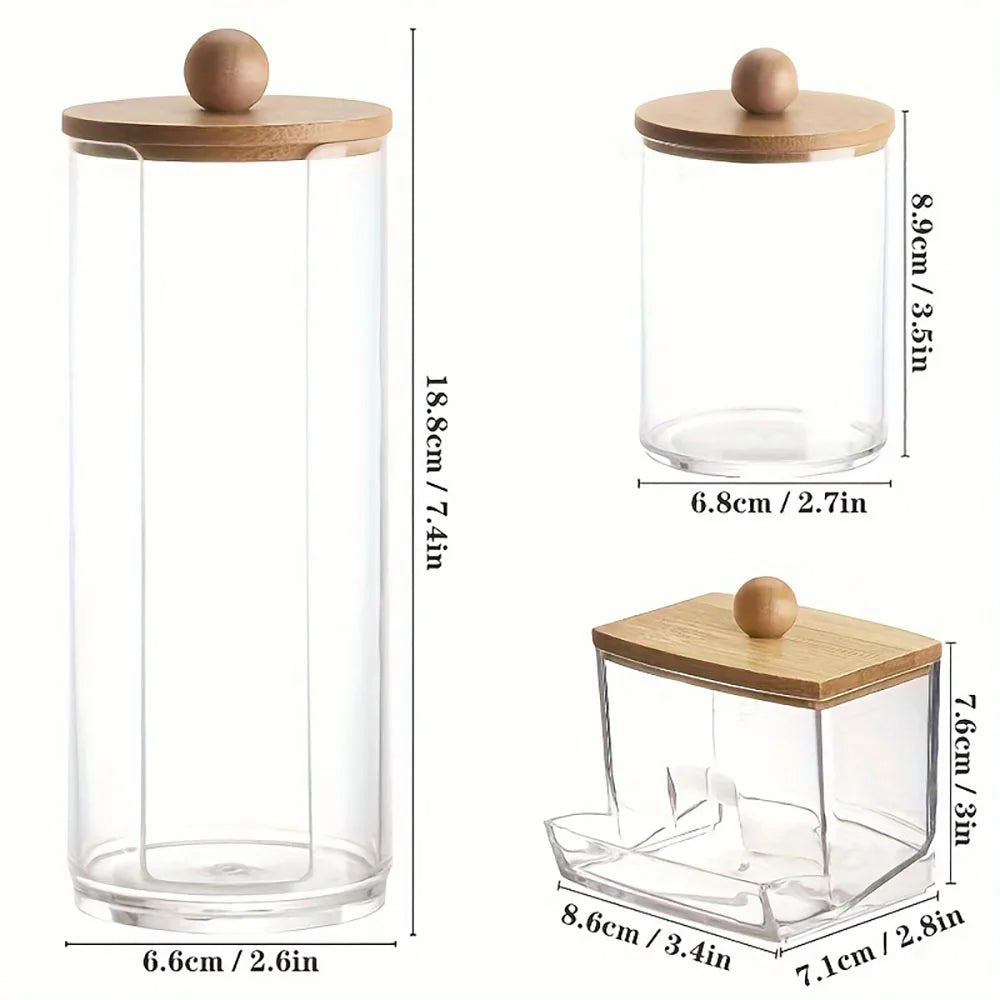 A clear glass bathroom organizer set featuring a cylindrical container and a square compartment with wooden lids.