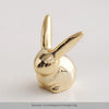 Gold-colored ceramic elephant and rabbit jewelry holder with a smooth, rounded design.