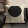 A beige linen cushion cover featuring a black geometric pattern of concentric circles and radiating lines.