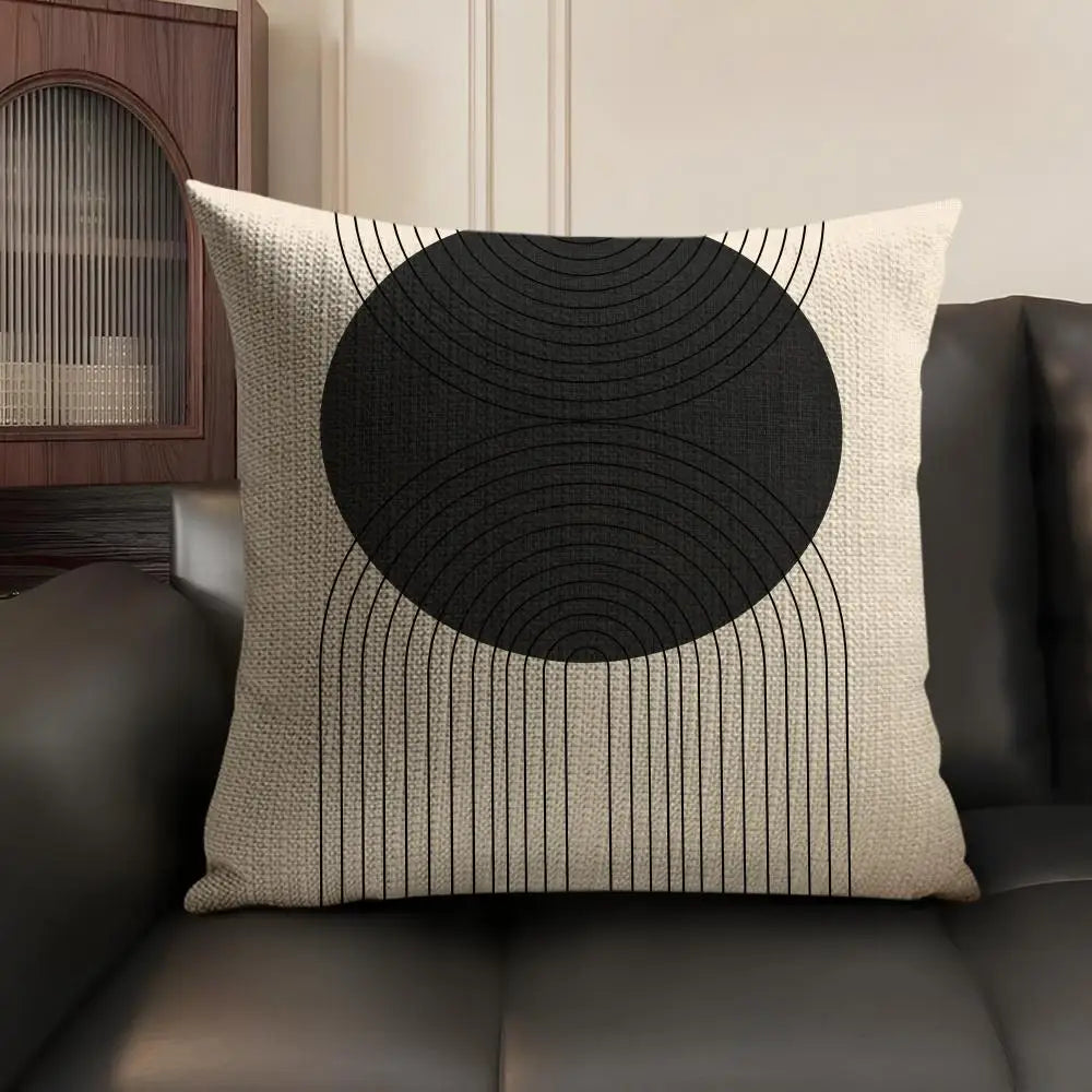 A beige linen cushion cover featuring a black geometric pattern of concentric circles and radiating lines.