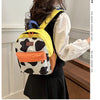 A woman is shown from the back wearing a yellow and black cow print backpack with orange accents.