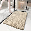 A beige plush velvet bathroom mat with a textured pattern is shown on a white marble floor.